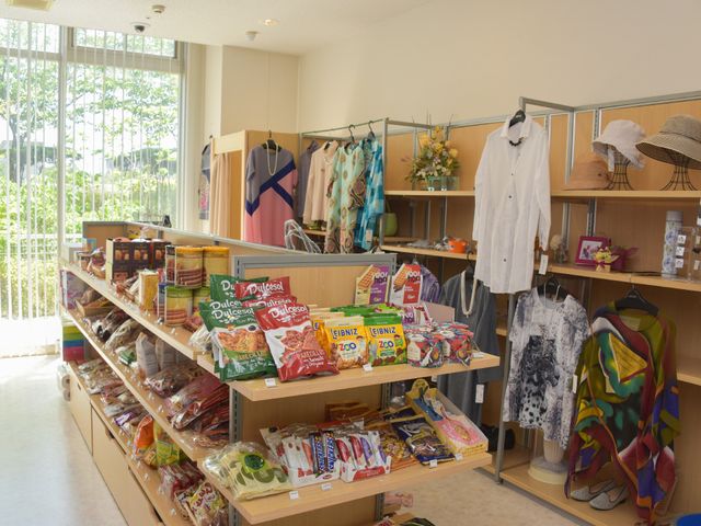 商品並ぶショッピングコーナー 売店 日用品からお洋服まで、多彩な品揃えのショッピングコーナーです。明るい光が差し込む店内で、お買い物をお楽しみください。