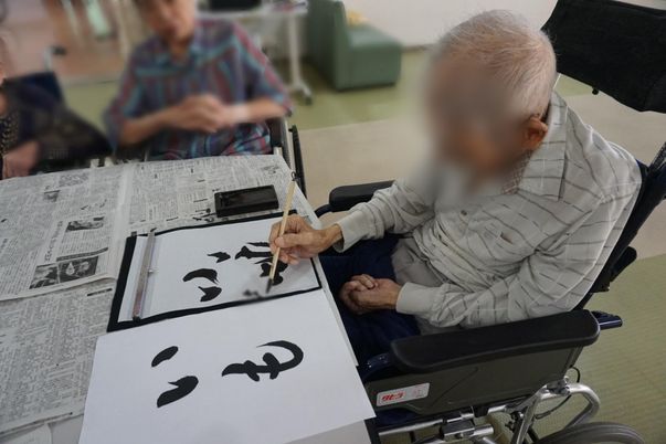 書道する人々の居室
