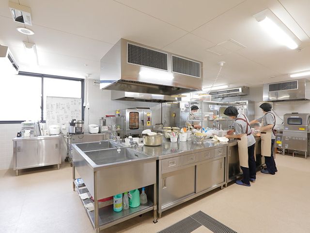 調理を行うスタッフの様子 キッチン キッチン 清潔なキッチンでスタッフが作業を進めています。広々とした空間で効率的な調理が可能です。