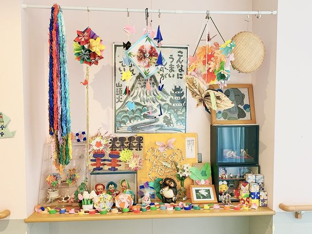 折り紙の装飾が際立つ壁面 掲示物 折り紙の作品が並ぶ壁は、施設内での多彩な活動の成果を示しています。創造性を引き出す場です。