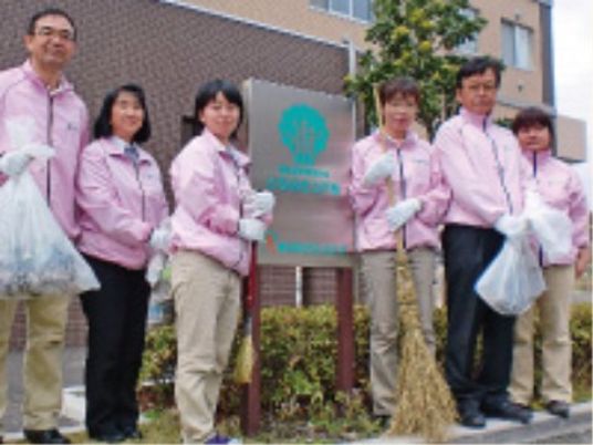 スタッフが看板前に立つ