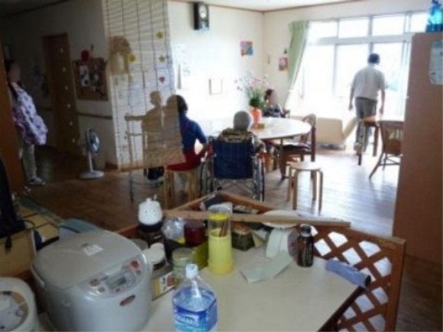 居室の日常風景 リビング・ダイニング ふだんの様子がうかがえる居室です。窓から自然光が差し込み、入居者の方々がくつろぐ姿が見られます。