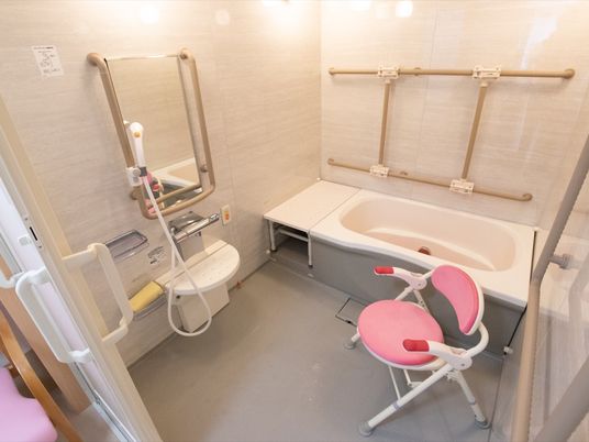 浴室の壁は、大理石風のデザインになっており上品な雰囲気である。広い洗い場スペースには、バスチェアーが置いてある。