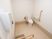 サムネイル ベージュと白でまとめられた落ち着いた雰囲気のトイレである。温水洗浄機能付きトイレの横には、緊急用呼び出しボタンがある。