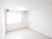 サムネイル 白を基調とした明るく爽やかな雰囲気の居室は、シンプルな内装になっている。オレンジ色のコードが、右側の壁に付いている。
