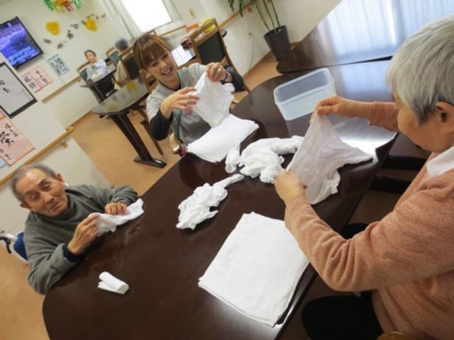 日常生活の様子 タオルの整理 明るく和やかな空間で、職員が利用者の方々と共に楽しそうに活動を行っています。このような交流は利用者の方にも喜ばれることでしょう。