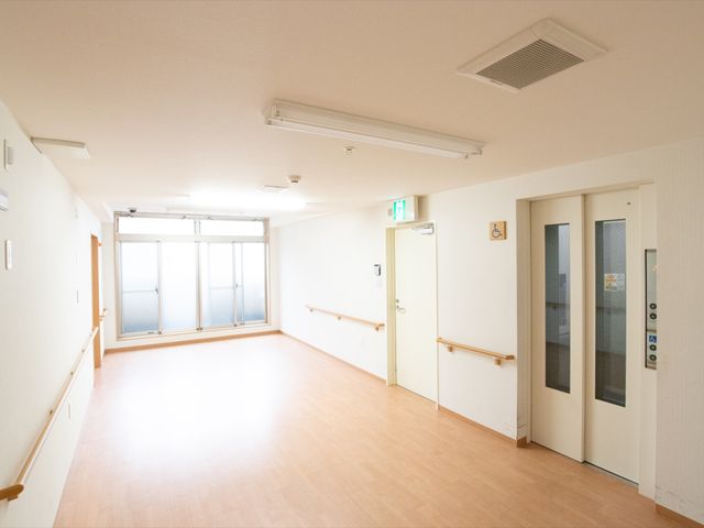 広々とした明るい廊下 廊下 手すりが設置された廊下は、明るく広々としており移動がしやすい環境です。日当たりの良い窓からは、穏やかな光が射し込んでいます。