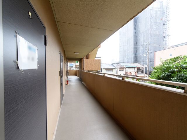 廊下と背景の建物 通路 清潔感があり開放的な廊下を備えた施設です。安全な移動環境を大切にしています。