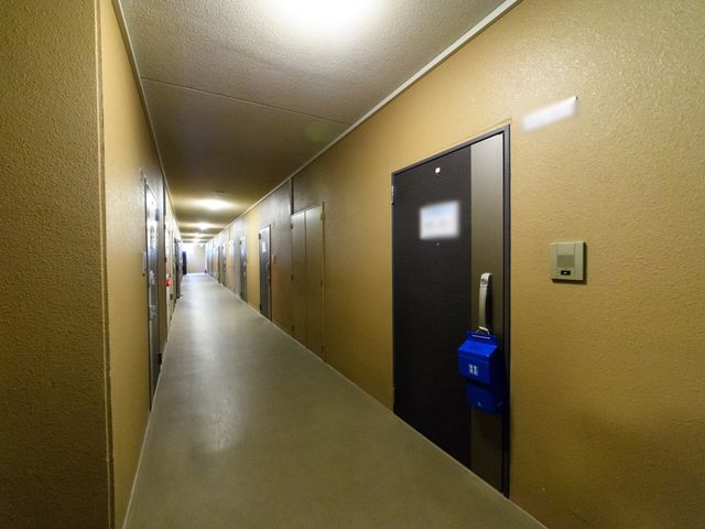 廊下の照明と扉の様子 廊下 綺麗で明るい廊下が続いており、清潔感が感じられます。作業中の方々への配慮も行き届いている環境です。