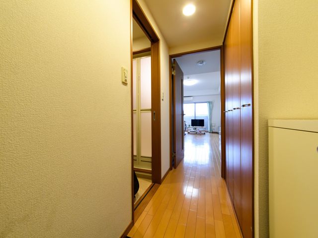 廊下からリビングの風景 居室 温かみのある明るいフローリングの居室です。共有スペースへの出入りも容易で、日々の生活がしやすい開放的な作りになっています。