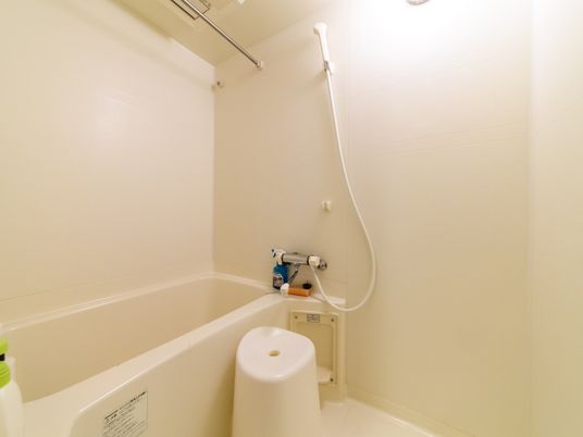 施設の写真 浴槽とシャワーがあるシンプルな浴室である。洗い場にはイスが置かれている。レバー式の水栓を採用している。