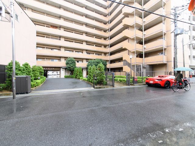 明るい建物のエントランス 外観 周囲に緑が豊かで落ち着いた雰囲気の建物入口です。雨の日も安心して出入りができる広めのアプローチが特徴的です。