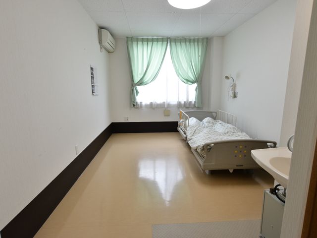 清潔な個室の居室 居室 ゆったりとした個室で、壁には時計や絵が飾られており居心地がよさそうです。手元に洗面台があり、日々の暮らしがしやすい配慮がなされています。