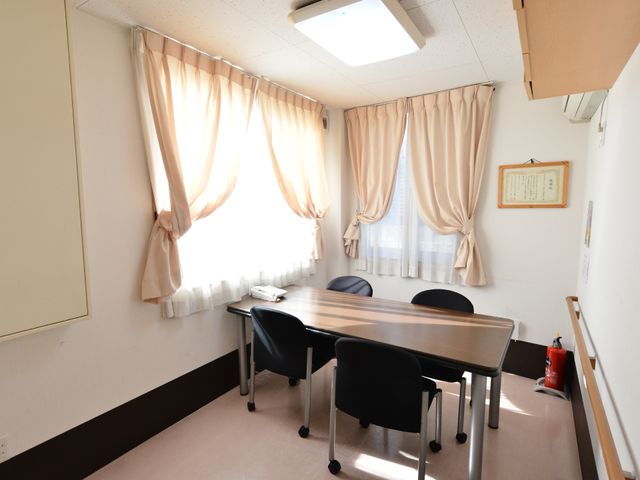 会議室の明るい昼間 相談室 窓から自然光が差し込む落ち着いた会議室で、ゆったりとしたチェアが配置され、心地よい対話ができる空間が整っています。