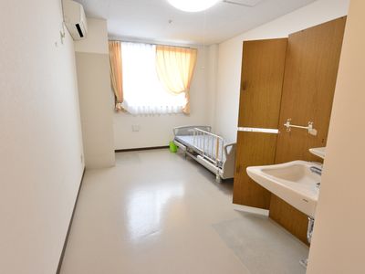 居室の洗面台とベッド
