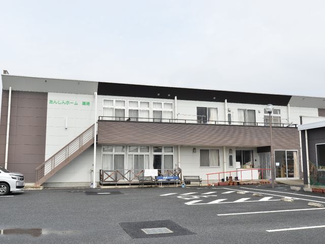 平屋建てのケアホーム外観 外観 広々とした駐車場があり、平屋建ての建物へのアクセスも良好です。ご高齢者の方々の安全な生活環境を大切に考えています。