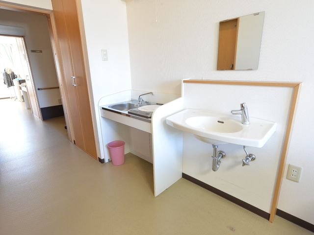 居室の洗面台とキッチン 居室 機能性を考えた居室の設えです。洗面台と小型キッチンが清潔感のあふれる空間に配されています。