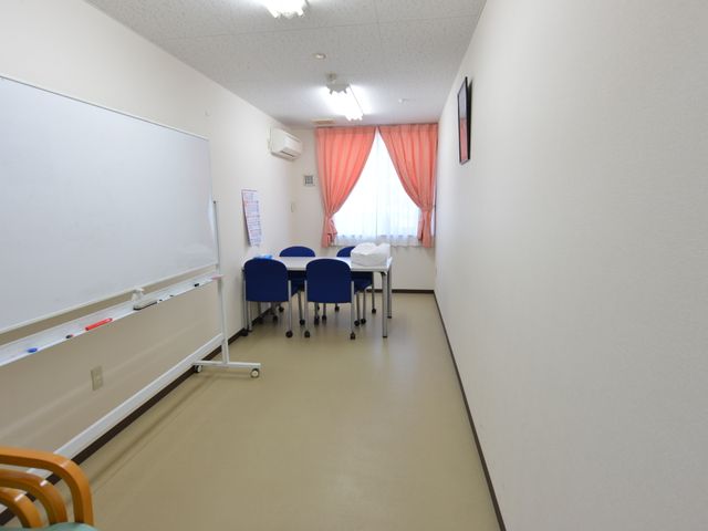 多目的スペースの明るい室内 相談室 広々としたクリーンな白壁の多目的室で、日々さまざまな活動が行えます。明るい窓辺で、静かな時間を過ごすことができます。