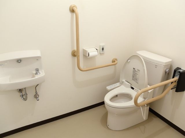 バリアフリー設計のトイレ トイレ 手すり付きの広々としたトイレ空間で、どなたでも安心してご利用いただけます。快適性と安全性を兼ね備えた環境をご提供しております。
