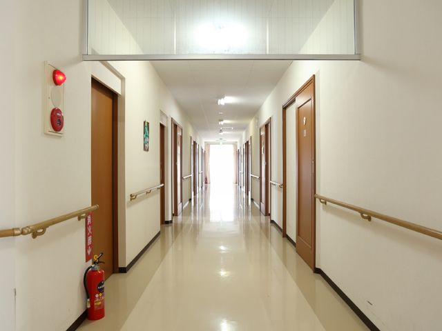 廊下の明るいイメージ 通路 手すりが設置された広々とした廊下です。ここを通じて、各お部屋へ安全にご移動いただけます。