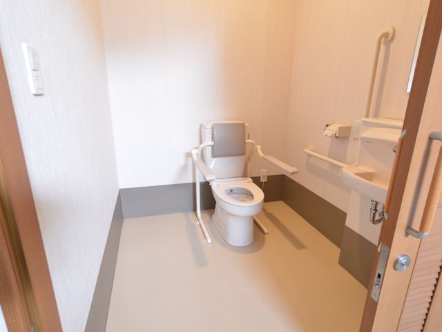 バリアフリートイレの内観 トイレ 安全かつ使いやすい設計のトイレ空間です。手すりが設置され、日々の生活を支える環境が整っています。