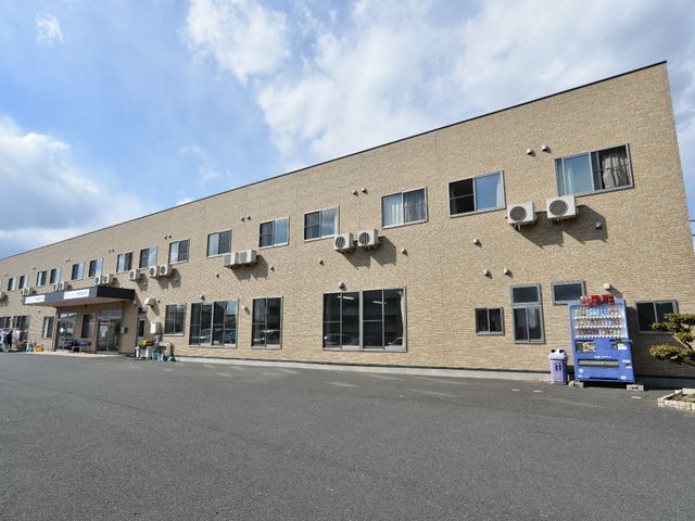 多階建ての建物外観 外観 明るい日差しが注ぐ屋外から見た、清潔感のある広々とした建物です。ゆったりとした出入り口が、快適なアクセスをお約束します。