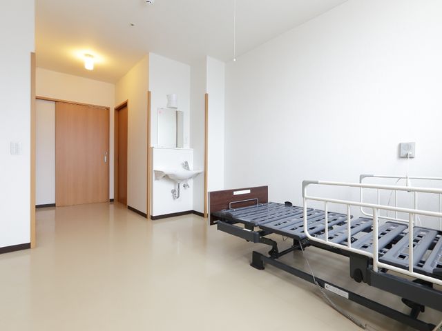 シンプルな洋室 居室 清潔感のある明るい居室が備わり、日々のくつろぎに適した環境が整っています。手元には必要な物が置ける家具も装備されています。
