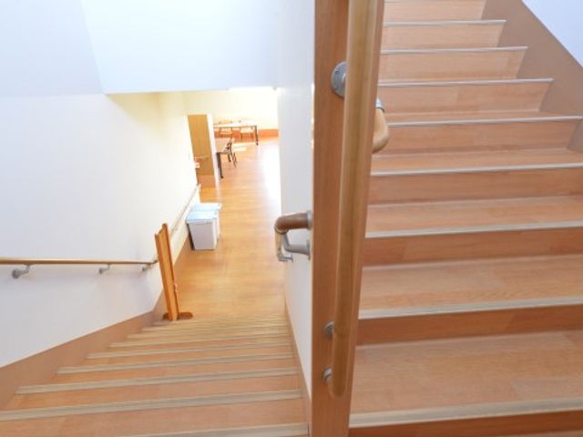 階段と上がる廊下の景色 内観 手すりが設置された明るい階段を上がると、清潔感のあふれる廊下が続いています。職場環境が整った空間でのお仕事をご検討ください。