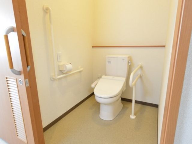 手すり付きのトイレ空間 トイレ 手すりが取り付けられた広々としたトイレです。どなたでも安全にご利用いただける配慮がされています。