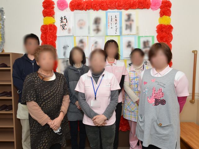 集合する人々の場 スタッフ 和やかな雰囲気の中で、スタッフと利用者の方々が交流している様子が伝わります。ここでは、あたたかいコミュニケーションを大切にしています。