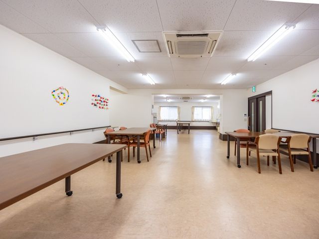 ゆったりした多目的室 多目的室 壁に装飾が施された広々とした多目的室です。テーブルと椅子が配置され、集会や様々な活動に適しています。