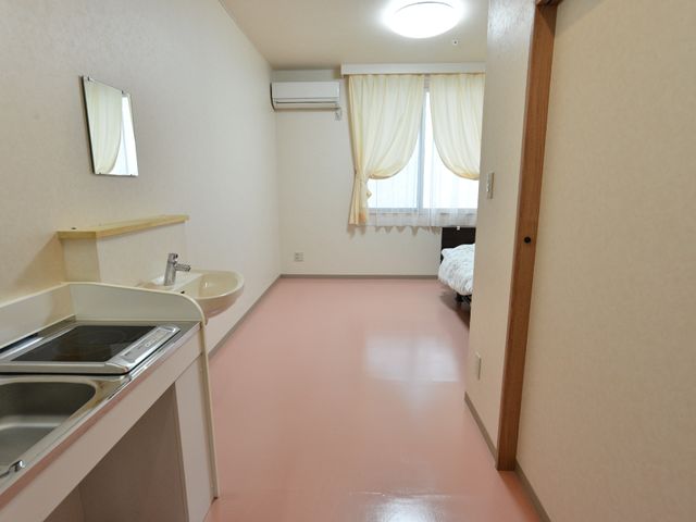 居室の一角と設備 居室1 ゆとりのある居室には、日々の生活に必要なキッチンや洗面設備が整っており、快適な環境が提供されています。