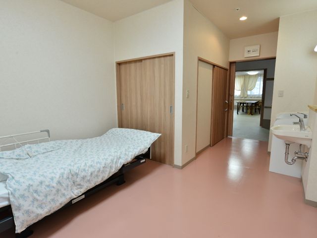 居心地の良い居室 居室2 清潔感のあふれる個室で、ゆったりとした時間を過ごせる環境が整っています。遠くからも食堂の明るい光が見え、温かな雰囲気を感じられます。