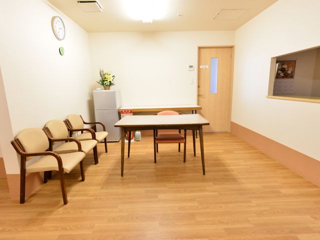 休憩用の椅子とテーブルのある部屋 共有スペース 広々とした休憩室ですね。木目調の床が温かく、憩いの時間を過ごせる空間が提供されています。