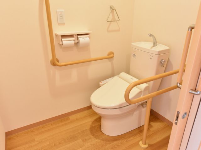 バリアフリーのトイレ設備 洋式トイレ 手すり付きの清潔なトイレで、安全かつ自立した日常生活のサポートを目指しています。利用者の快適さを考えた設計です。