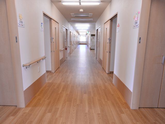 清潔な明るい廊下 廊下の様子 手すりが設置された光あふれる明るい廊下です。職員の方々も清掃を行いやすい設計になっており、快適な職場環境が整っています。