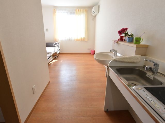 居室の明るい一角 明るい個室 床材には温かみのある木目調を採用しており、日当たりの良い居室でゆったりと過ごせます。必要な設備が整った空間です。