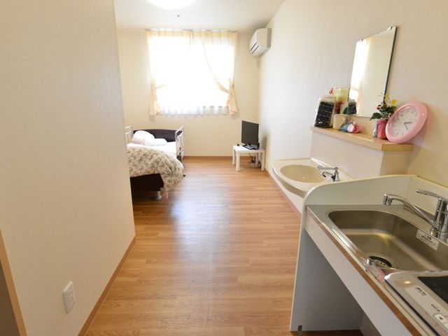 居室の様子 部屋 温かみを感じさせる居室です。ベッドや洗面台が整い、快適に過ごせる空間が備わっています。