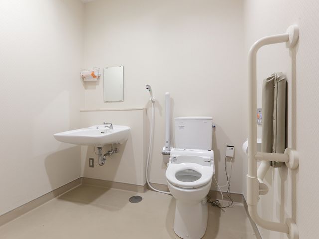 バリアフリーの洋室トイレ トイレ 手すりや広いスペースを備えたトイレです。利用者の安全と自立をサポートする設計になっており、就業を検討される方に安心をお届けします。