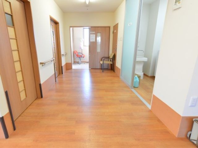 明るい廊下と部屋の扉 イベント ゆったりとした通路が特徴の廊下です。手すりや座れるスペースもあり、居心地の良さを感じていただける環境が整っています。