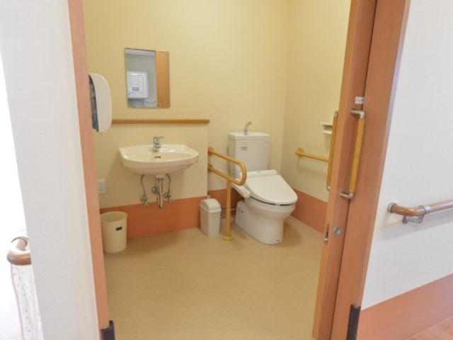 明るく清潔なトイレ トイレ 手すりや広々としたスペースを備えた明るいトイレです。安心してご使用いただける環境が整っています。