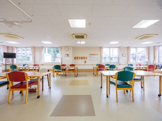明るい食堂の机と椅子 食堂   大きな窓から光が入る、ゆったりした食堂です。複数のテーブルがあり、落ち着いて食事や会話がしやすそうです。