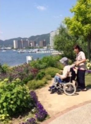 車椅子の利用者とスタッフ中庭