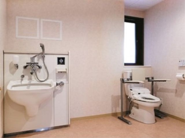 バリアフリー設計のトイレ トイレ 手すりや高さ調節が可能な機能が完備された清潔なトイレ空間です。利用者の安全と利便性を第一に考えた配慮がされています。
