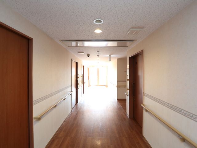 明るい施設の廊下 通路 ゆとりのある廊下は、手すりが整っており、日差しの温もりを感じながら安全にお過ごしいただけます。