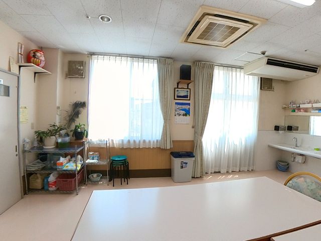 明るい共有スペース ダイニングルーム 天井の高いダイニングルームは明るく清潔感があり、物品の整理も行き届いております。利用者様が日々の食事や交流を楽しむ場として最適な環境です。