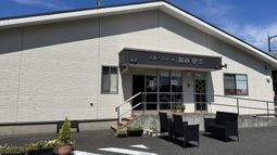 白い壁の建物と駐車場