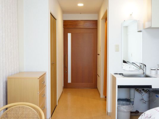 部屋のドアは大きく横にスライドさせるタイプ。一部が不透明ガラスになり、外からの光がはいる。部屋には洗面台がある。
