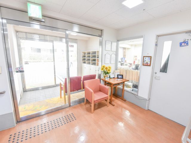 エントランスの明るい空間 入り口 歓迎する雰囲気のエントランスには、くつろぎやすい椅子が配され、訪れた人を温かく迎え入れます。