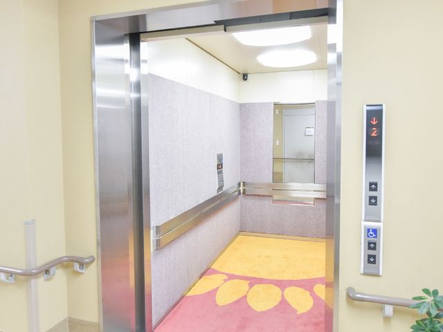 明るいエレベーター エレベーター 手すりが設置された広々としたエレベーターは、バリアフリー設計です。安心して利用でき、明るい色使いが気持ちを和ませます。